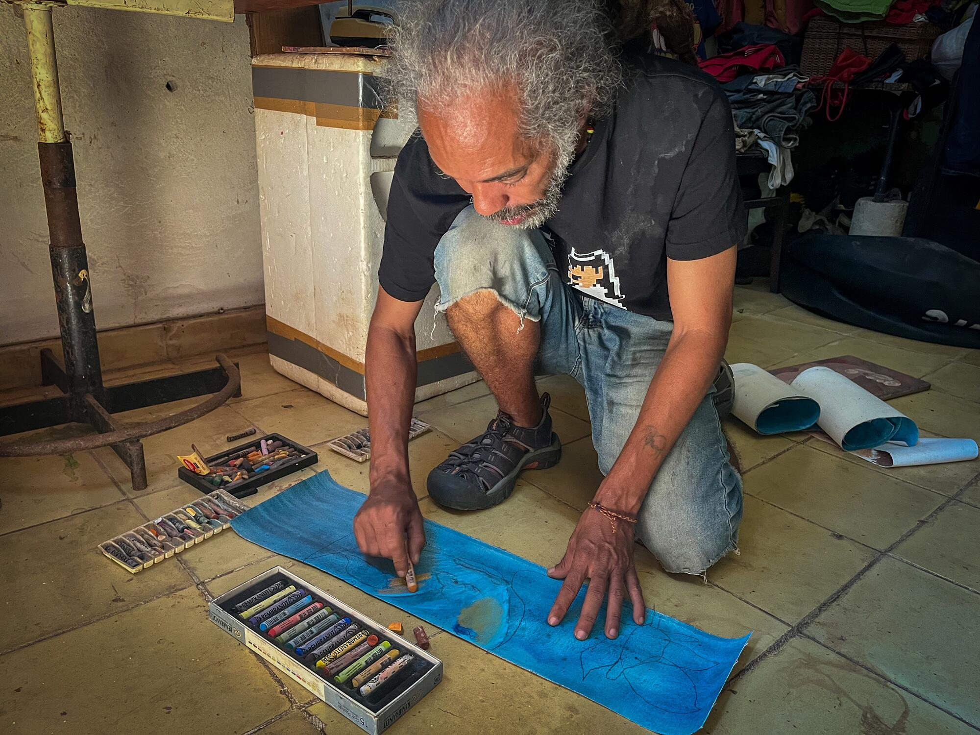 Joel, artista del barrio de Alamar (La Habana), pinta un lienzo en su casa