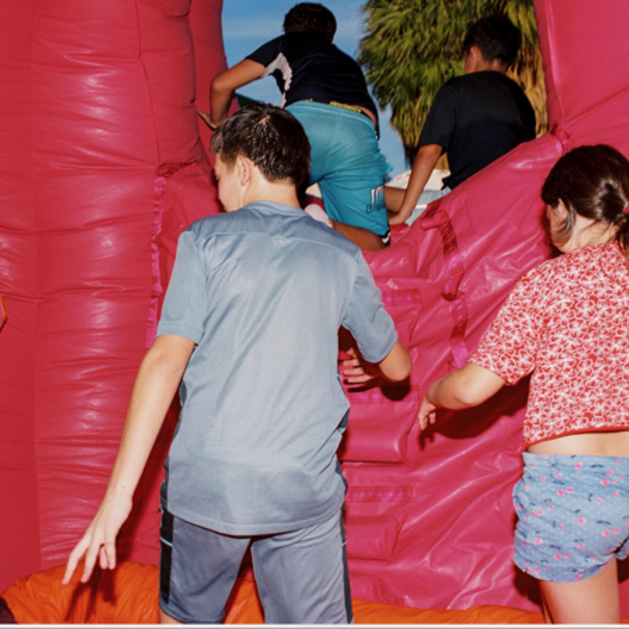 Niños jugando con la escultura hinchable