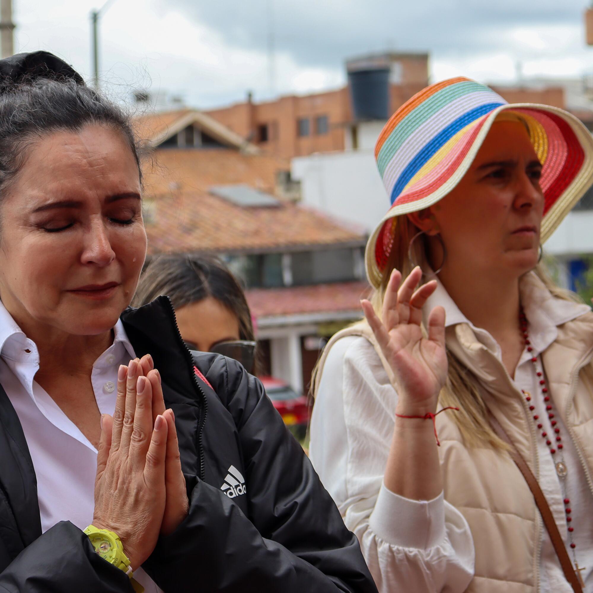 Simpatizantes de Miguel Uribe Turbay rezan fuera de la clínica.