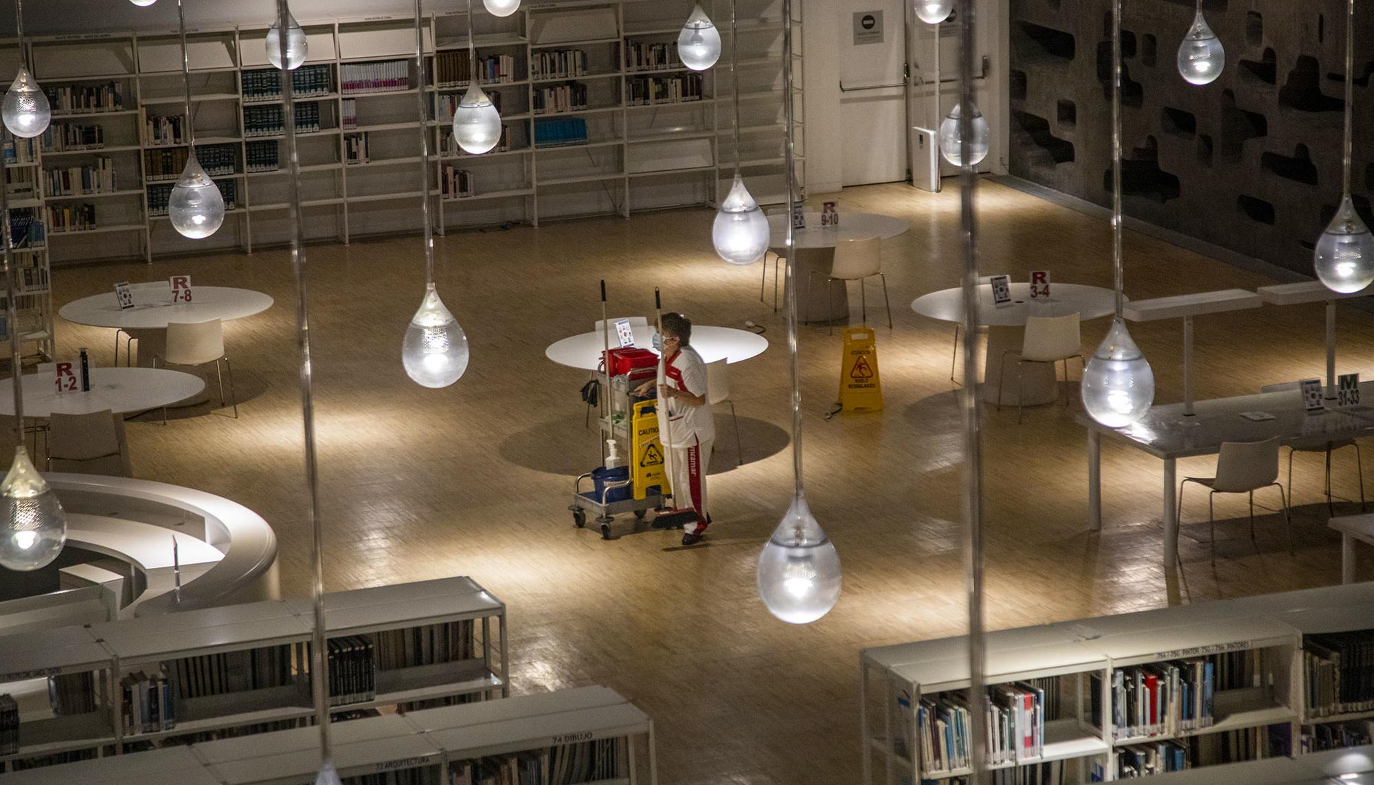 Una trabajadora de la limpieza en una biblioteca