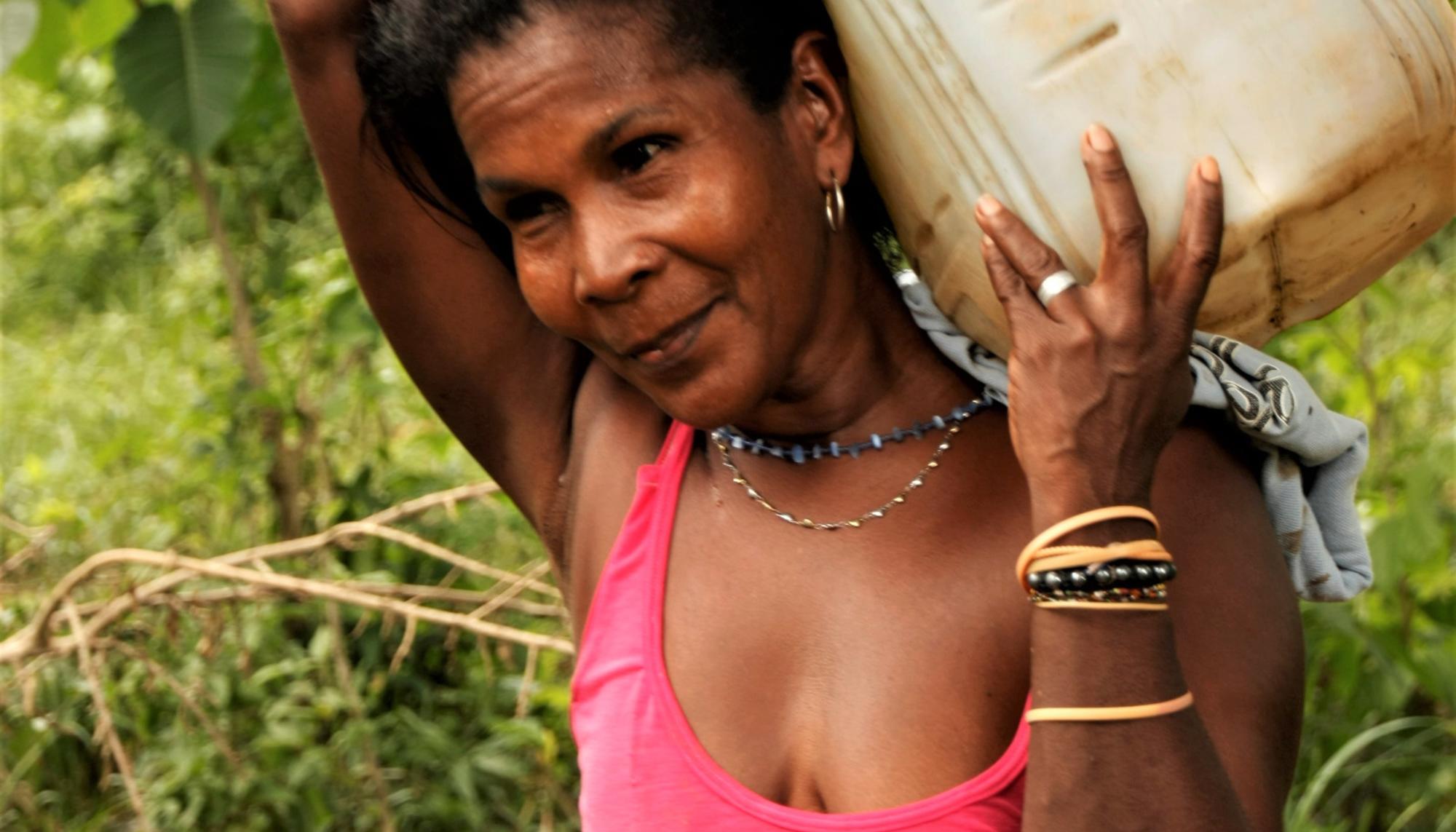 Mujer transportando agua en Colombia