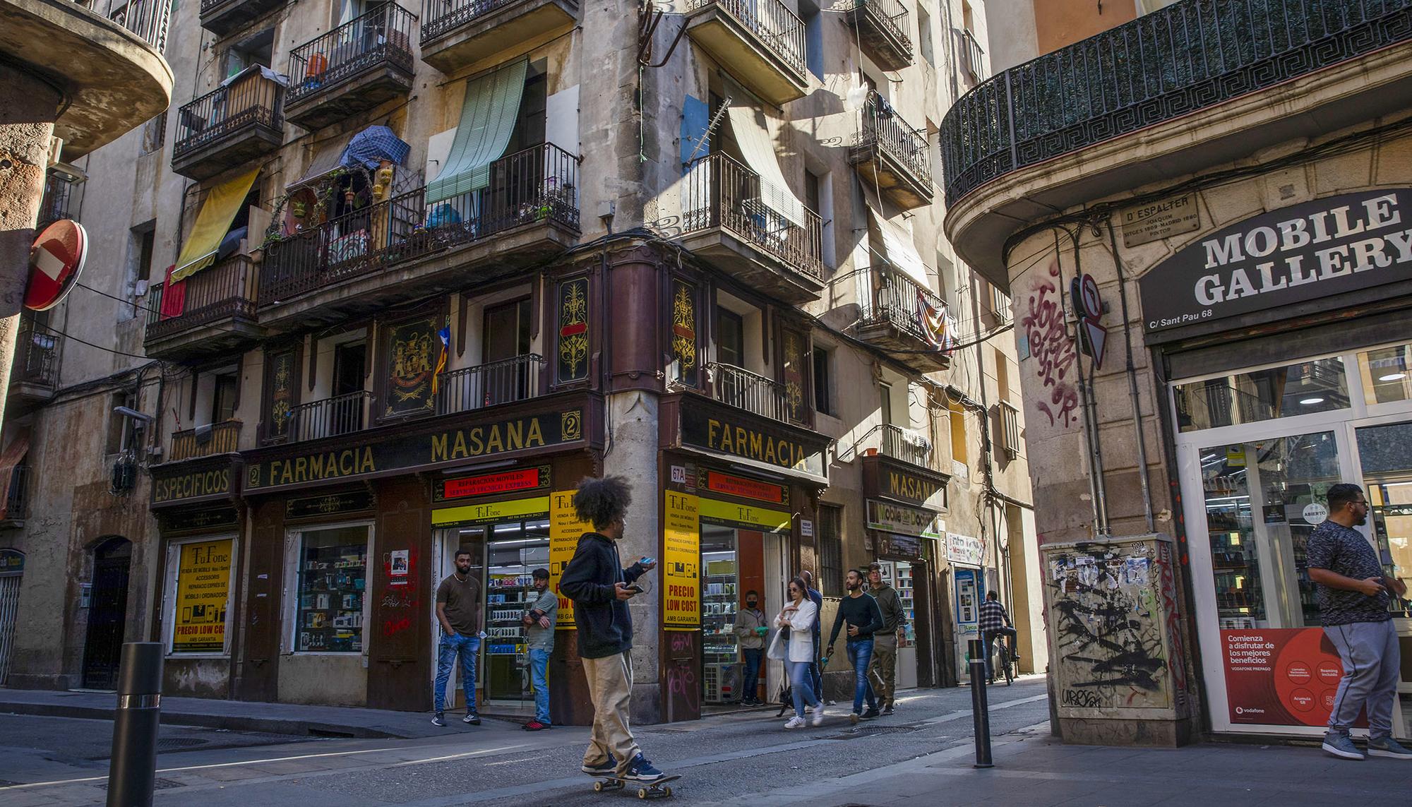 Un chaval en monopatín por el Raval de Barcelona