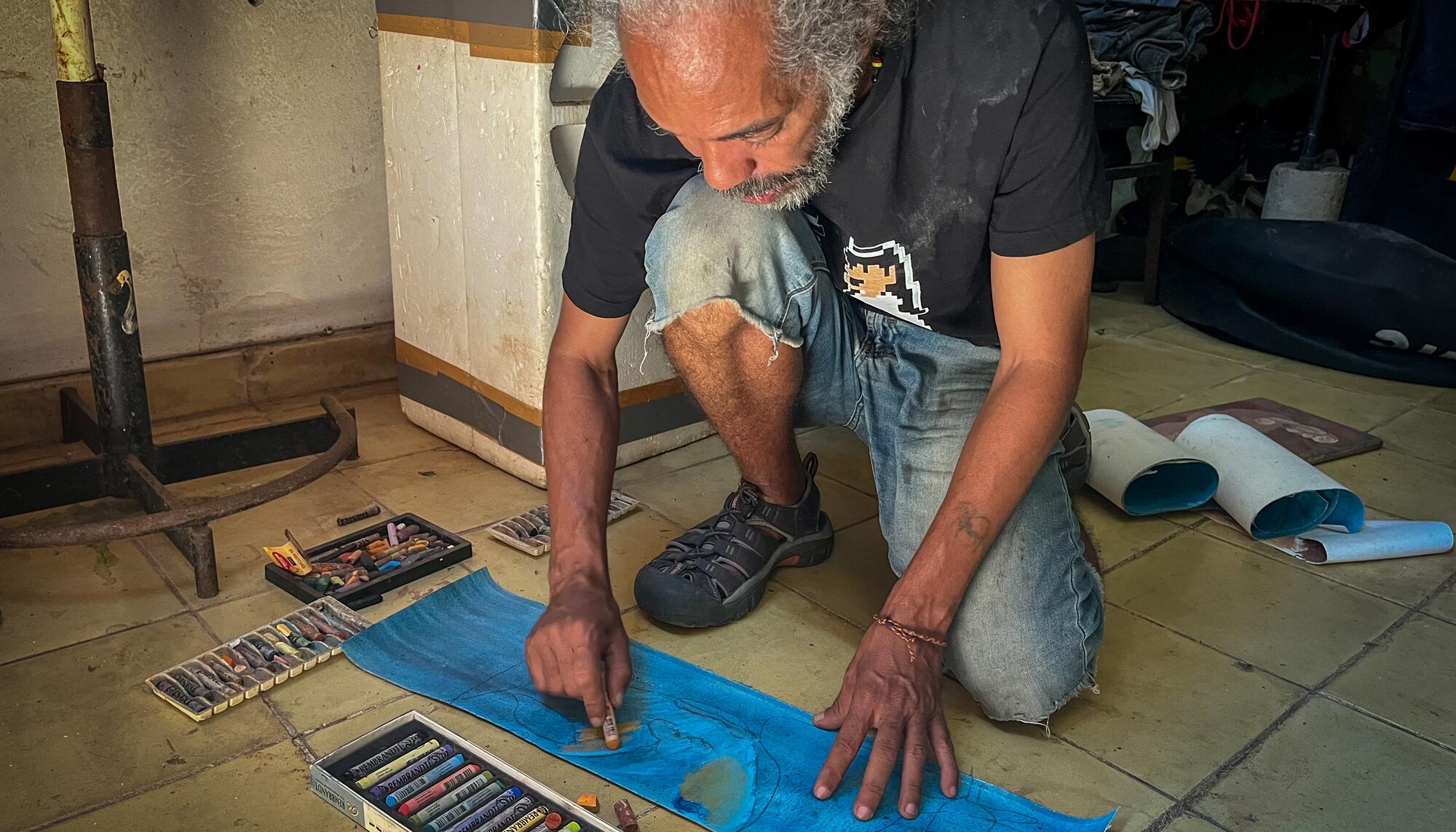 Joel, artista del barrio de Alamar (La Habana), pinta un lienzo en su casa