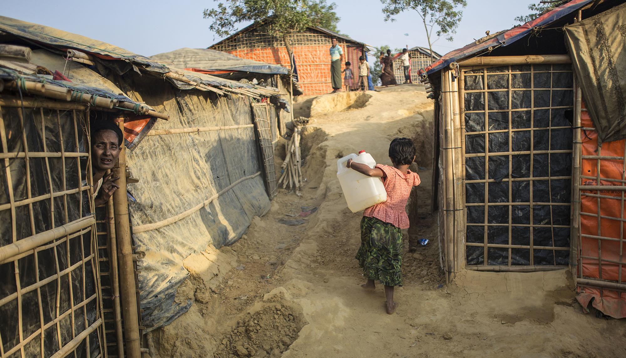 Una niña rohingya transporta un bidón de agua