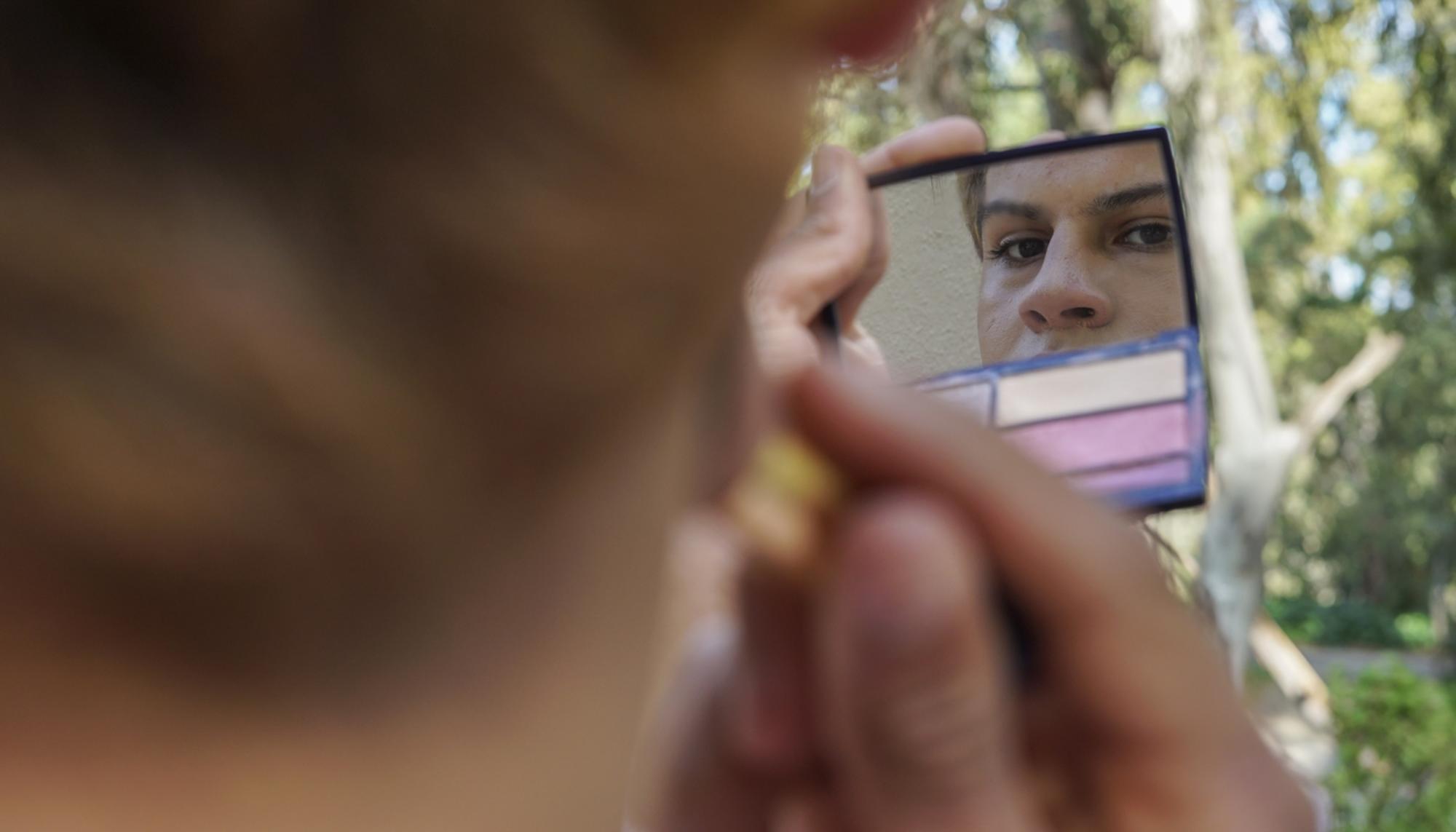 Magia, una joven trans de 19 años, se maquilla a las puertas del CETI de Ceuta.