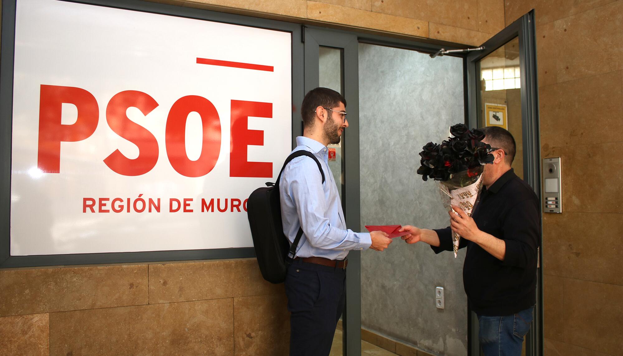 Activistas de solidaridad con Palestina entregan un ramos de rosas negras en la sede del PSOE de Murcia.