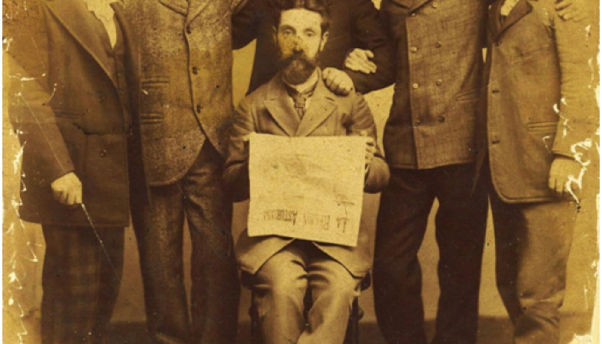 Eladio Carreño, sentado, con un ejemplar de "La región asturiana"