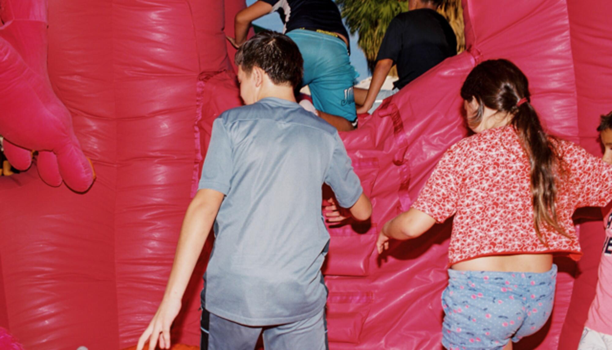 Niños jugando con la escultura hinchable