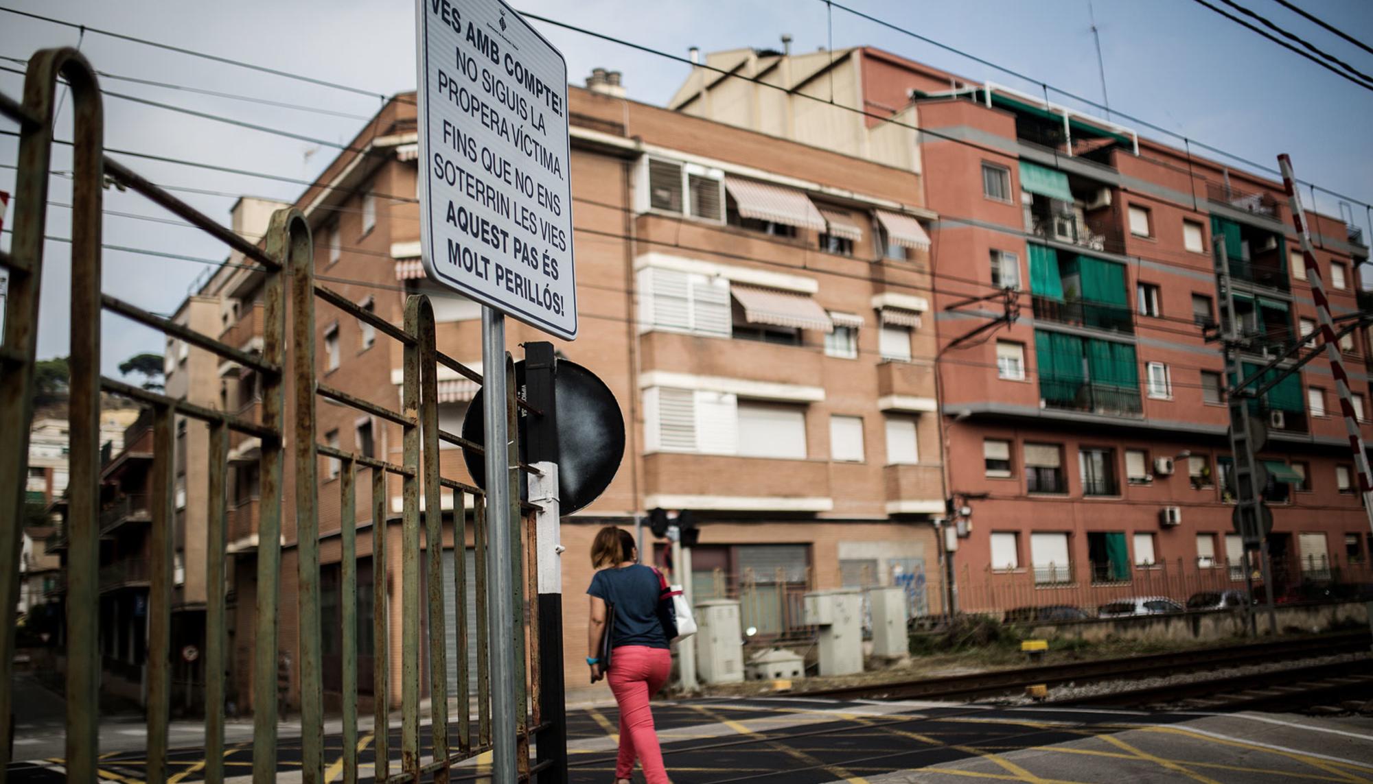 Mujer cruzando con cartel Montcada i Reixac