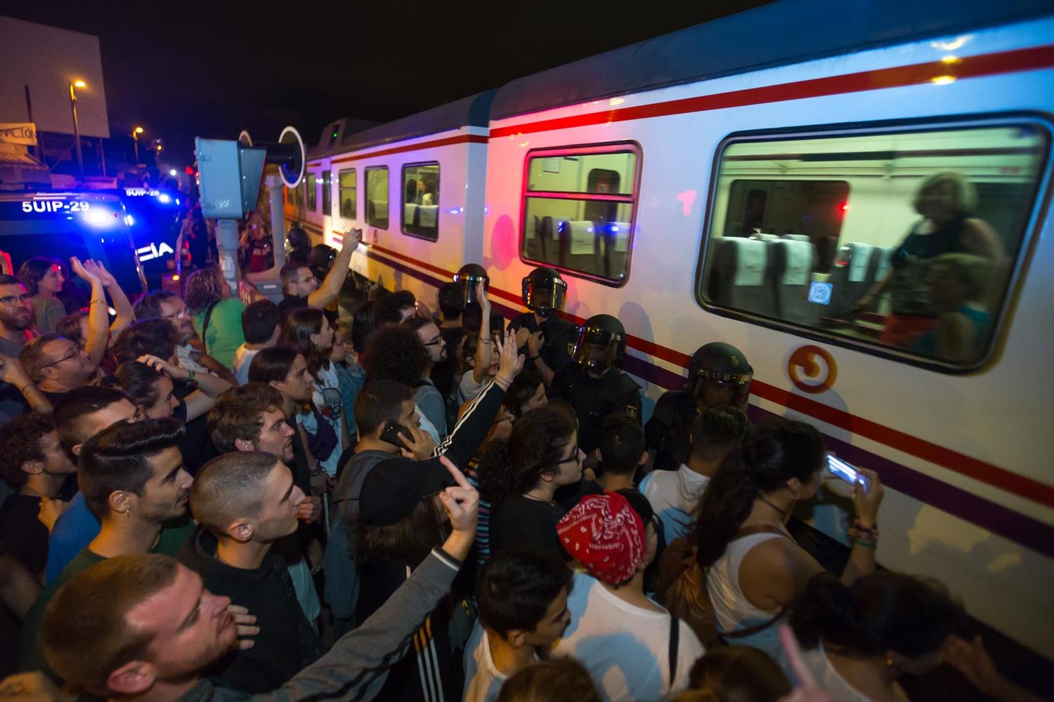 Una muralla de policías bloquea a los manifestantes que pitan al tren en su paso por Santiago el Mayor, Murcia