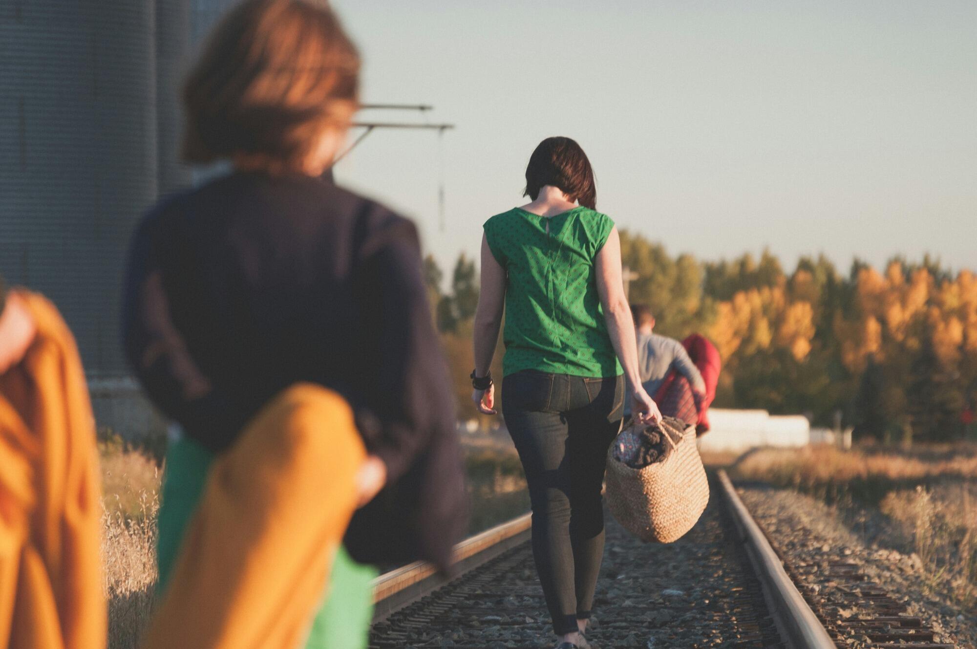 grupo de personas que caminan sobre la vía del tren