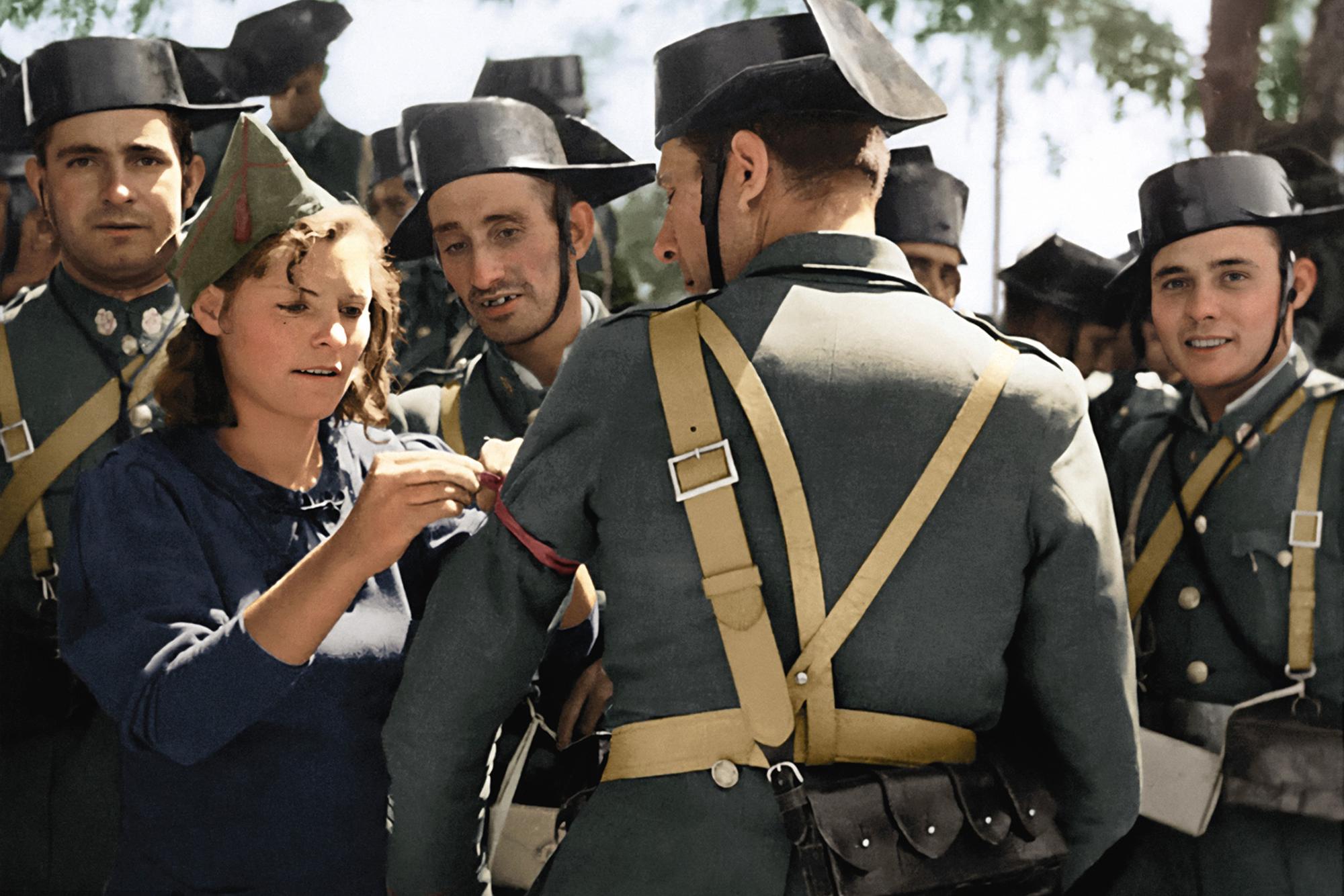 Miliciana coloca un lazo rojo a guardias civiles leales a la República.