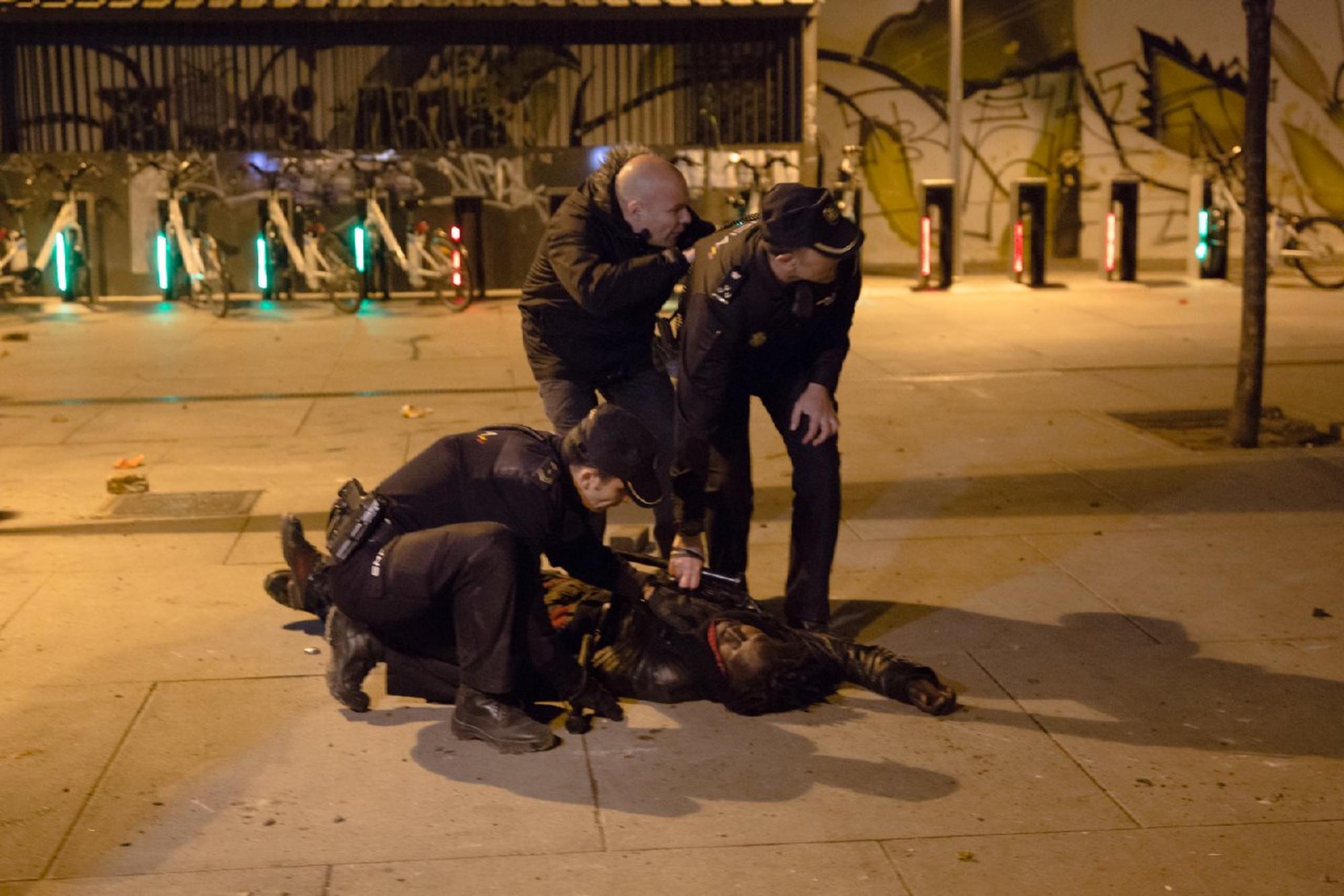 Agentes de policía reducen a un hombre durante los disturbios en Lavapiés tras la muerte de Mame Mbaye