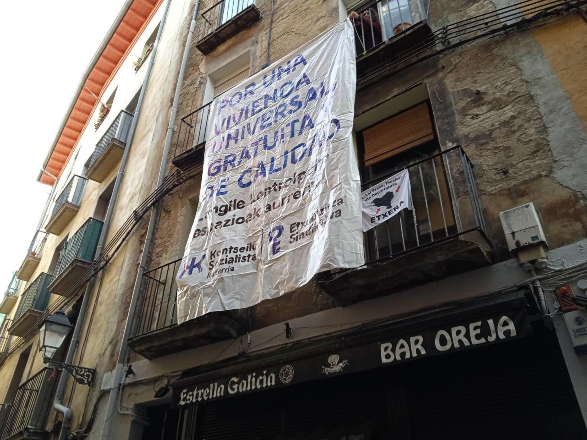 Pancarta cuelga desde los balcones del piso intervenido en calle Jarauta, Pamplona / Konstseilu Sozialista Iruñerria