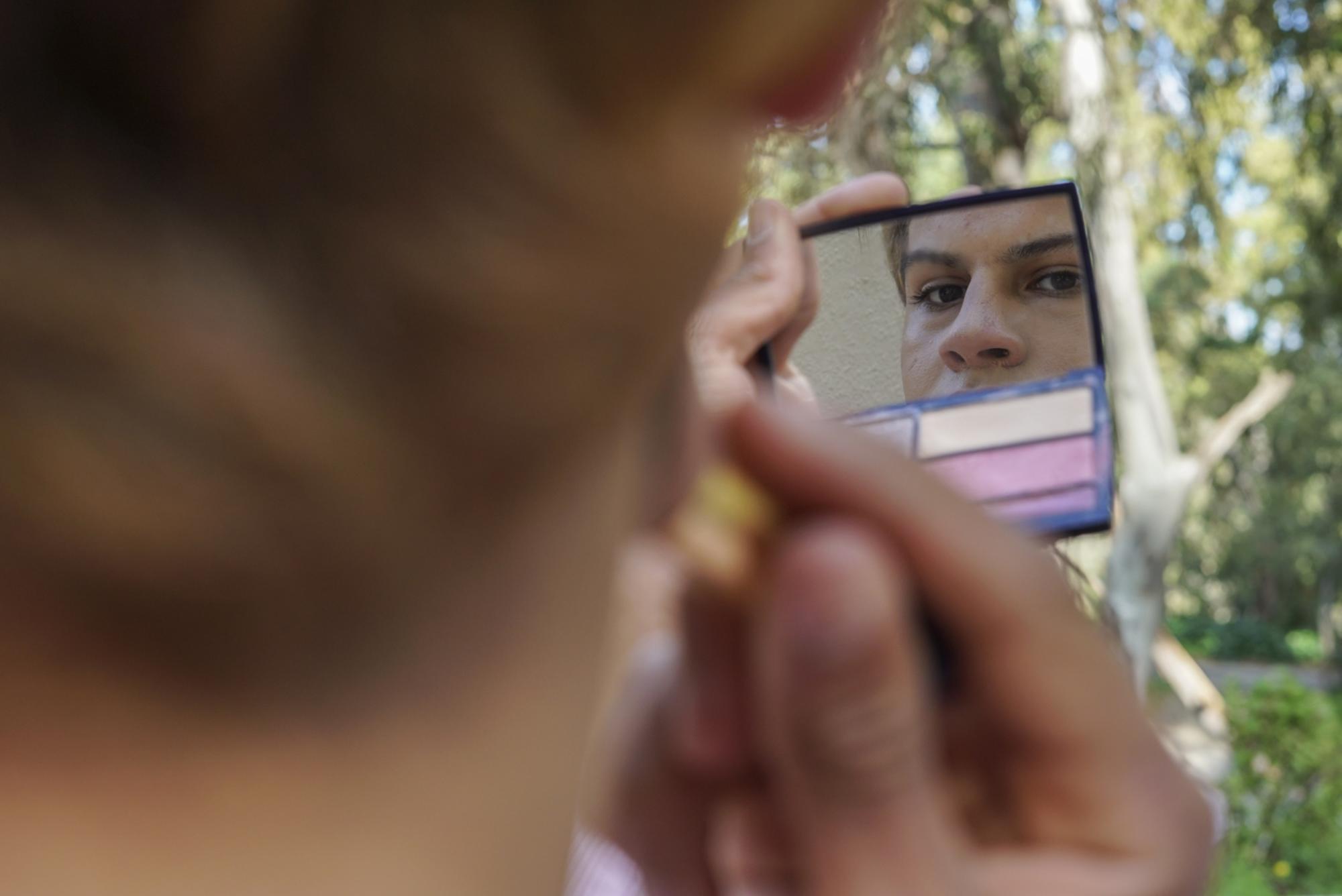 Magia, una joven trans de 19 años, se maquilla a las puertas del CETI de Ceuta.