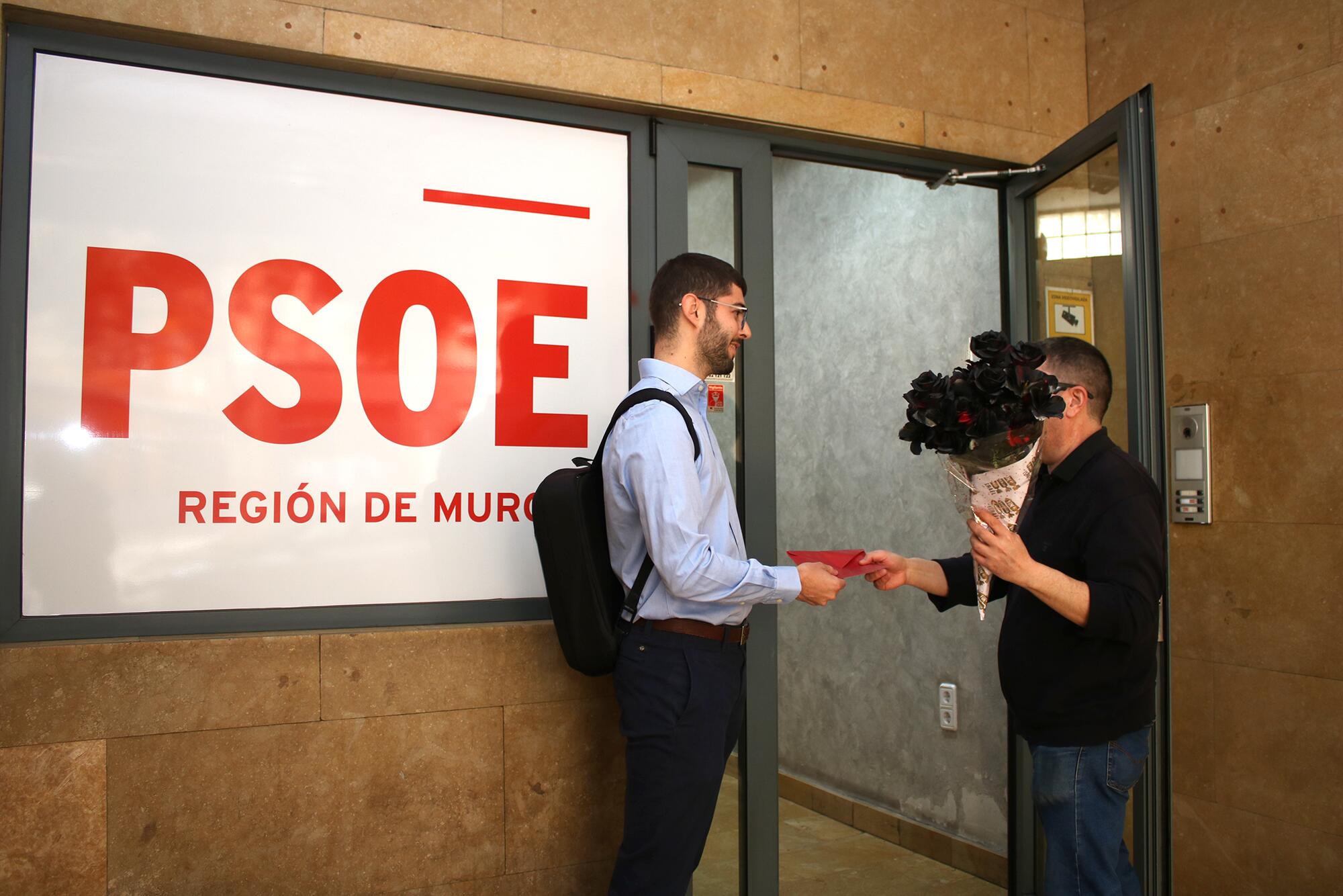 Activistas de solidaridad con Palestina entregan un ramos de rosas negras en la sede del PSOE de Murcia.