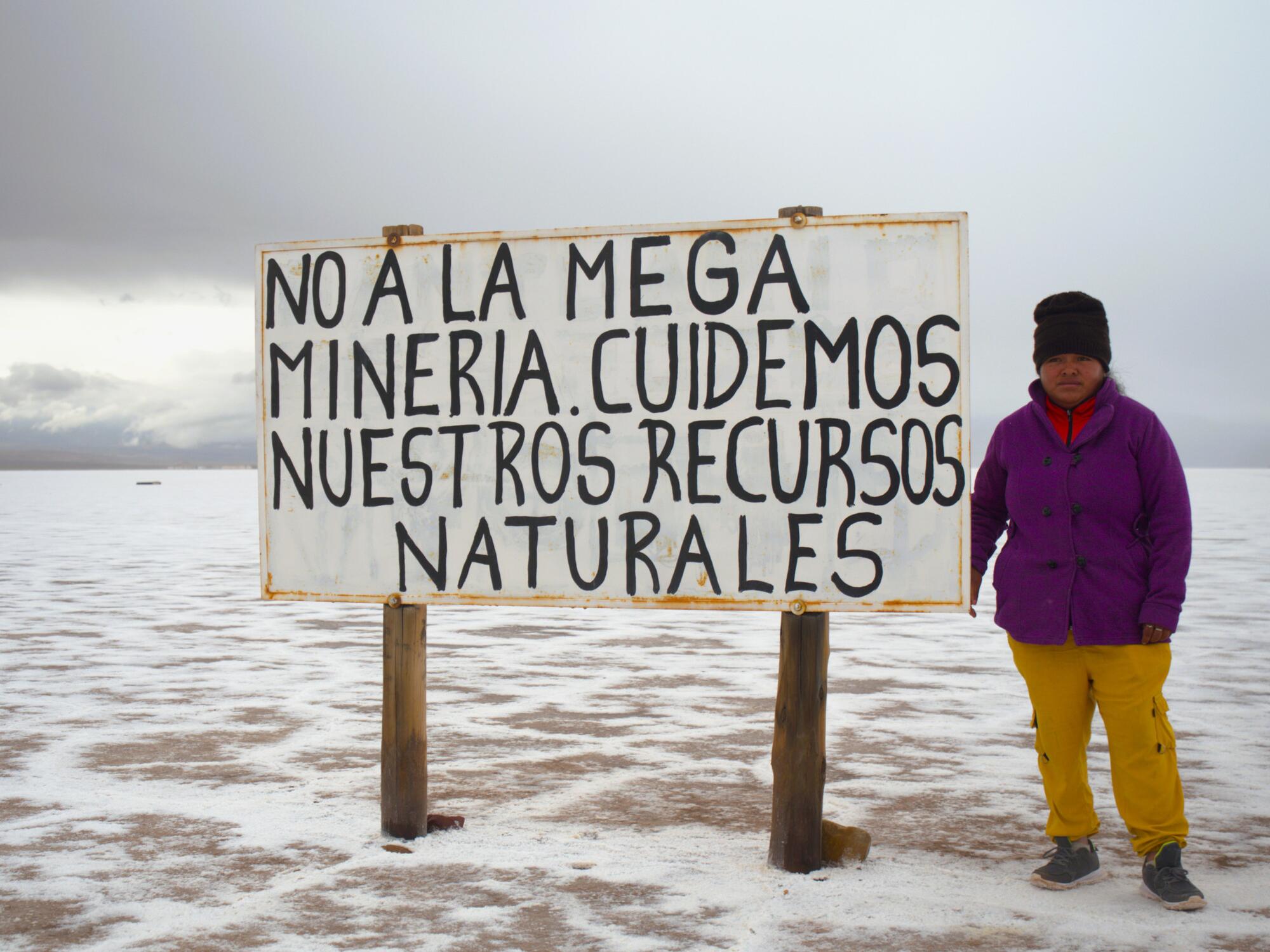 Comunario frente a un cartel contra la minería del litio.