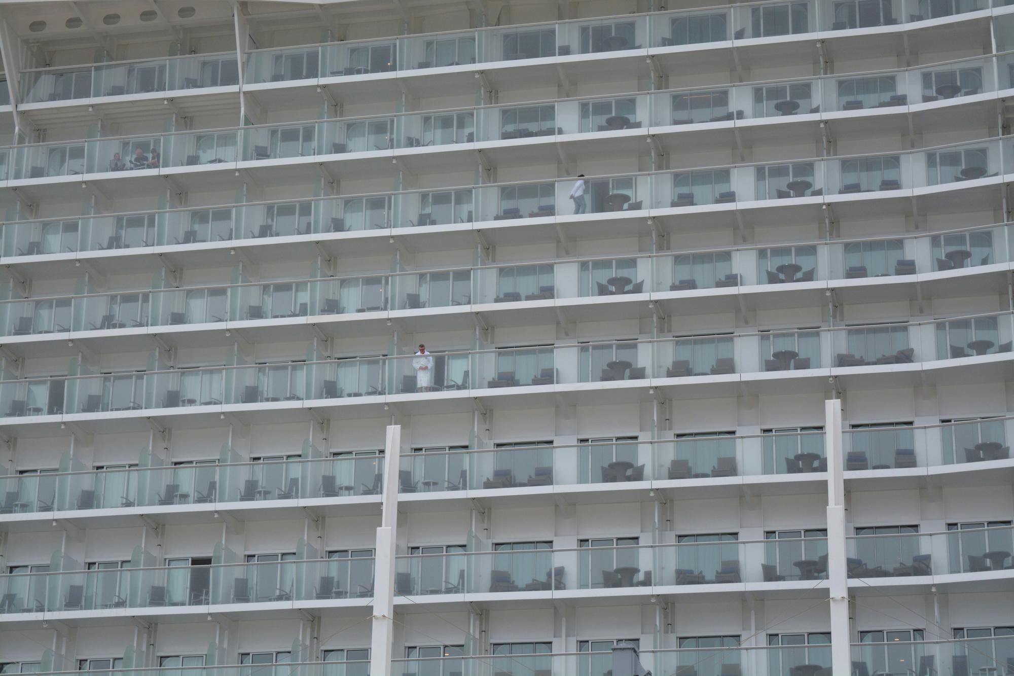 Un pasajero del crucero Symphony of the Seas se asoma a la terraza de su camarote