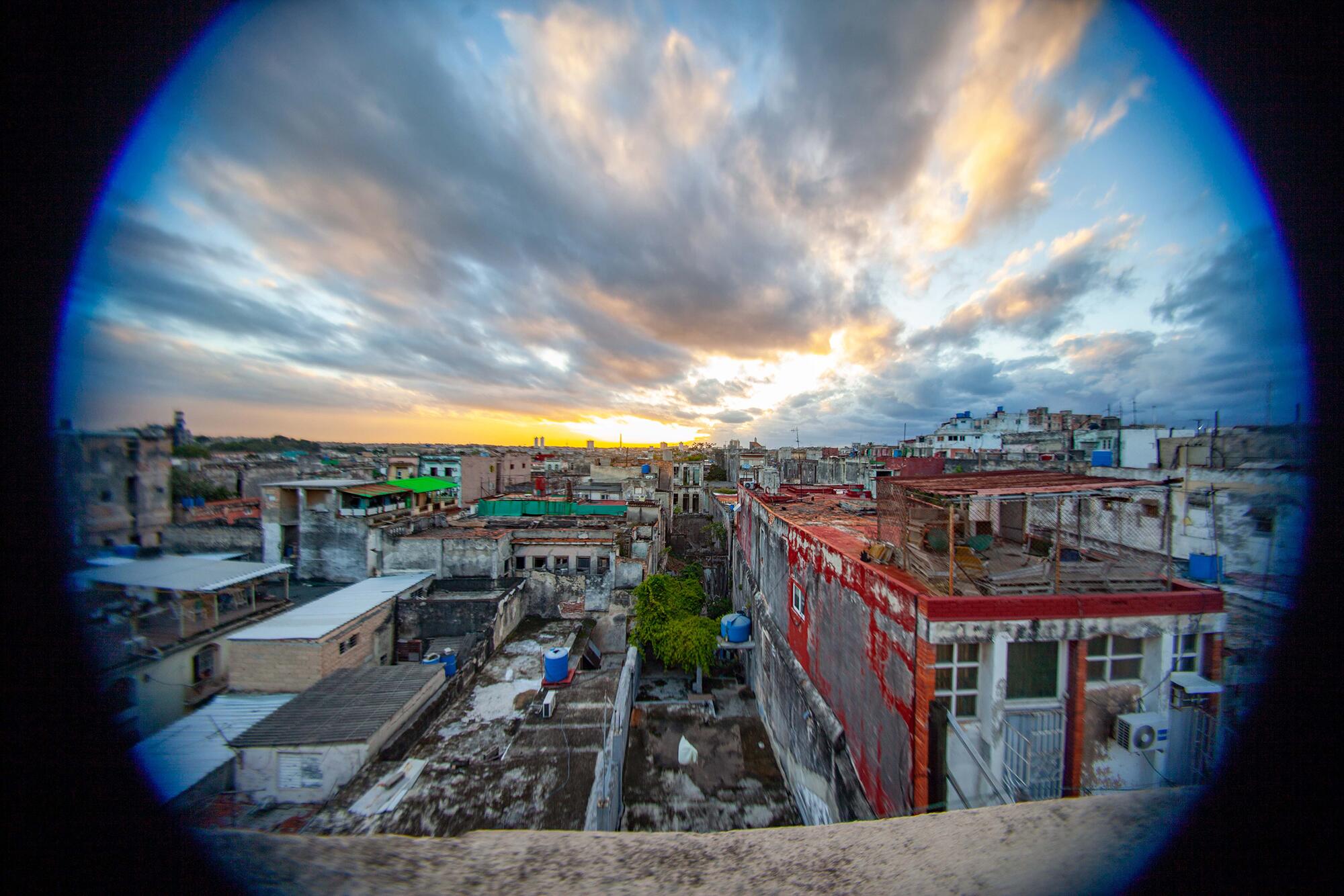 Elizabeth, de 21 años, sube al techo de su casa para observar su barrio, donde esta tarde de febrero no hay corriente eléctrica