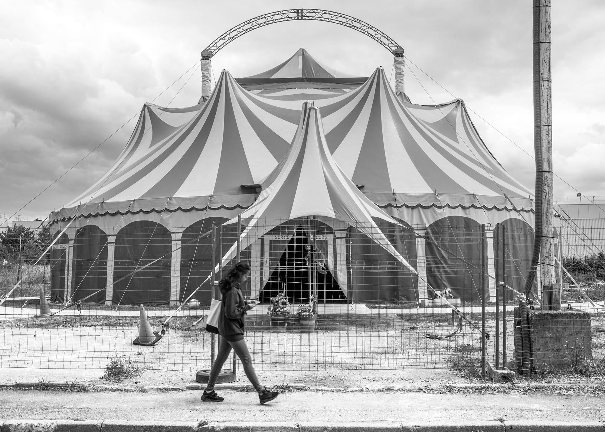 Una niña camina junto a la carpa de circo instalada cerca del barrio de La Noé, en Chanteloup-les-Vignes (Francia)