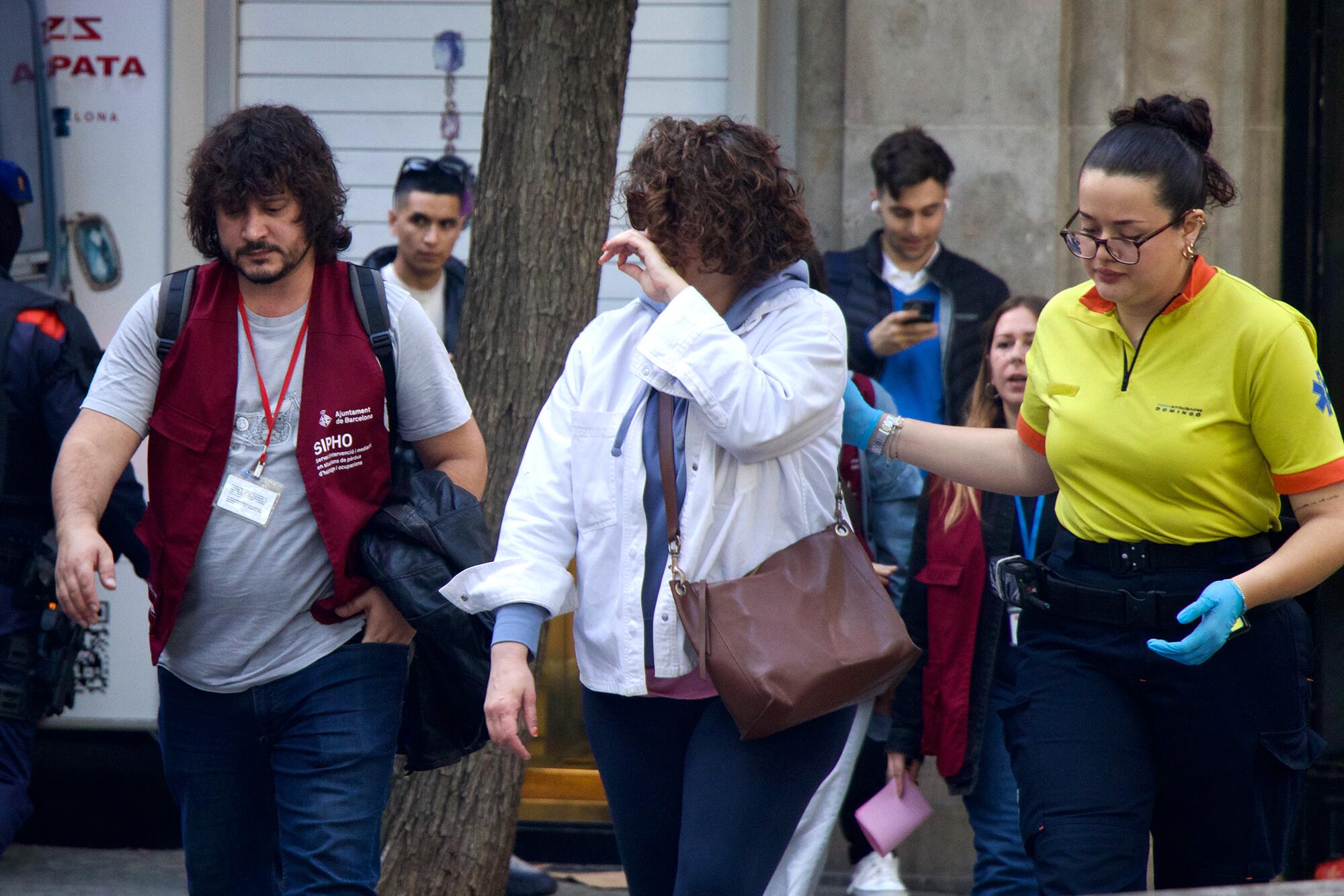 Olalla abandonando su piso acompañada de personal médico y un trabajador de SIPHO.