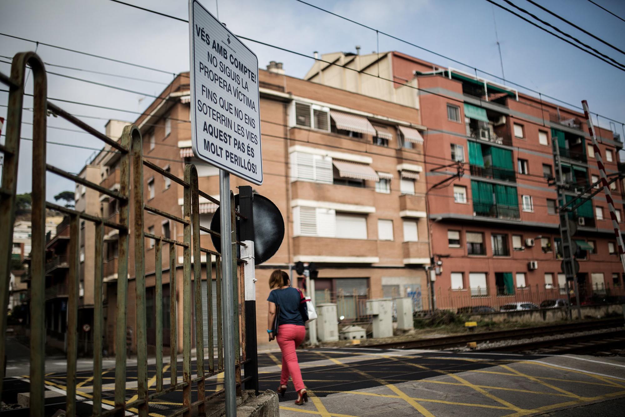 Mujer cruzando con cartel Montcada i Reixac