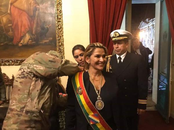 Un militar coloca la banda presidencial a la flamante presidenta de Bolivia, Jeanine Áñez, designada sin la participación de la Asamblea Legislativa, en donde el MAS tiene mayoría absoluta..